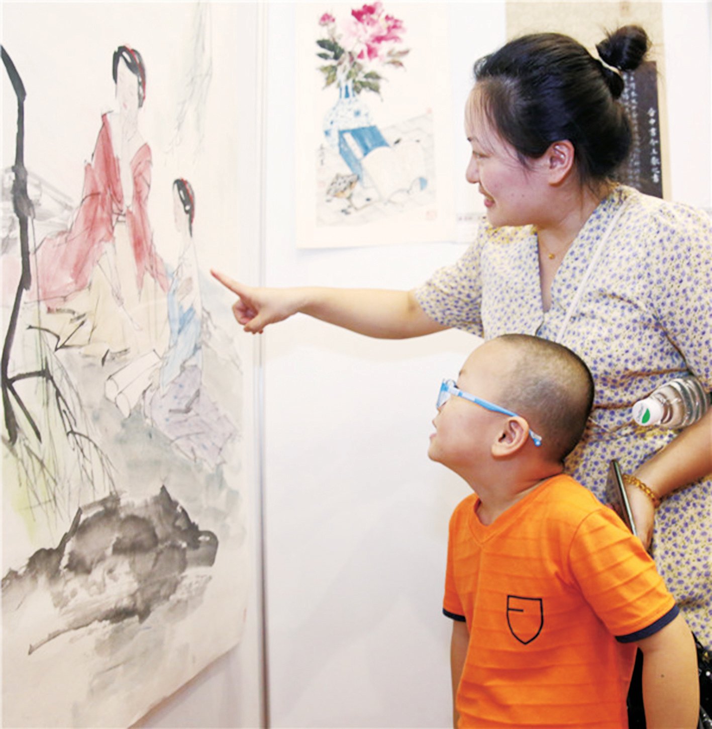 一位母亲带领孩子观赏作品