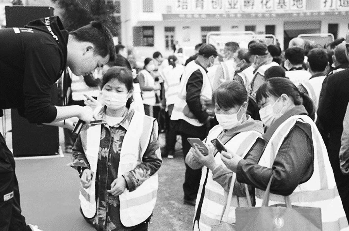 工作人员指导农民工扫码入会工作人员指导农民工扫码入会